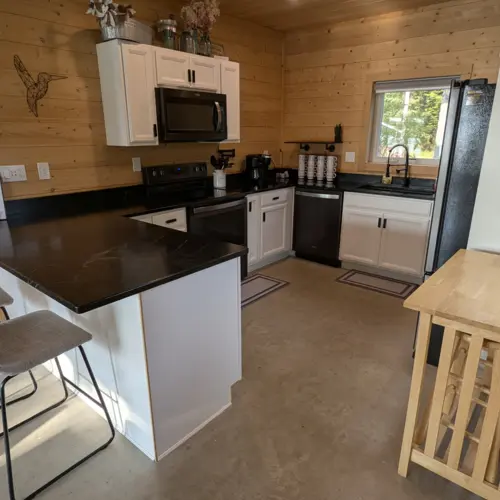 Iluminação embutida e armários modernos em nossa cozinha totalmente equipada criam um espaço luminoso e convidativo para cozinhar na casa do lago.